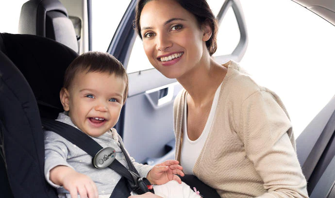 Photo of a smiling baby and mother with the Elepho eClip attached to the strap of the car seat